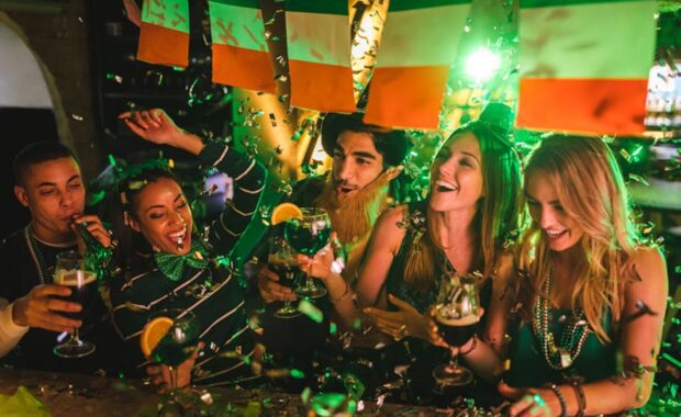 Happy multi-ethnic friends drinking and having fun at Saint Patrick's day night club party