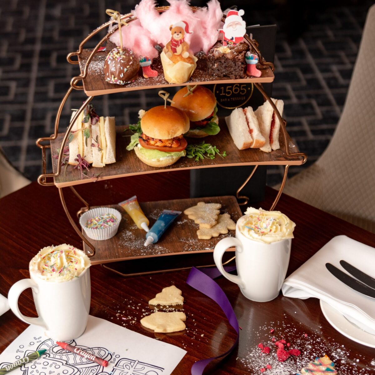 Three tiers of Christmas themed sweet and savoury items for children's afternoon tea